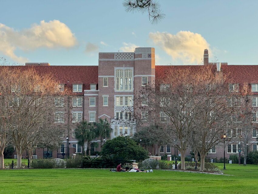 Students sit on blankets on Florida State University’s Landis Green on Dec. 31, 2024, with Landis Hall in the background.
