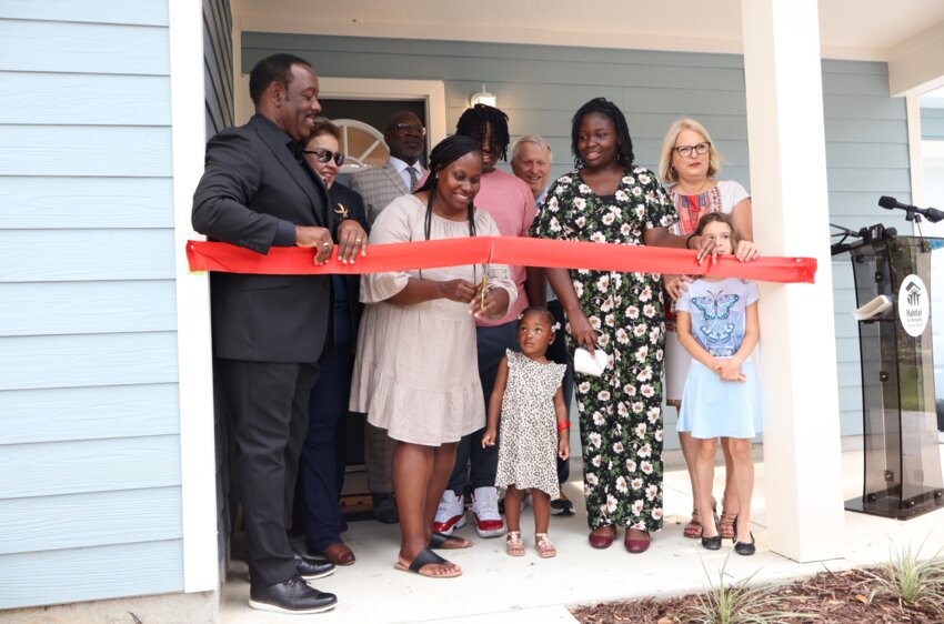 Keetonia Wilson cuts the ribbon at her new residence.