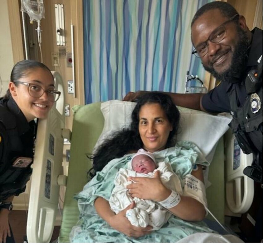 Apopka Police Officer Adsudalah Brooks (far right) and Recruit Officer Laura Crespo (far left) check in on Baby Geber and his mother, Eligia.