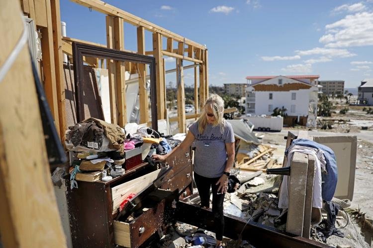 Candace Phillips sifts through what was her third-floor bedroom while returning to her damaged home in Mexico Beach, Fla., Sunday, Oct. 14, 2018, in the aftermath of Hurricane Michael. David Goldman / AP Photo