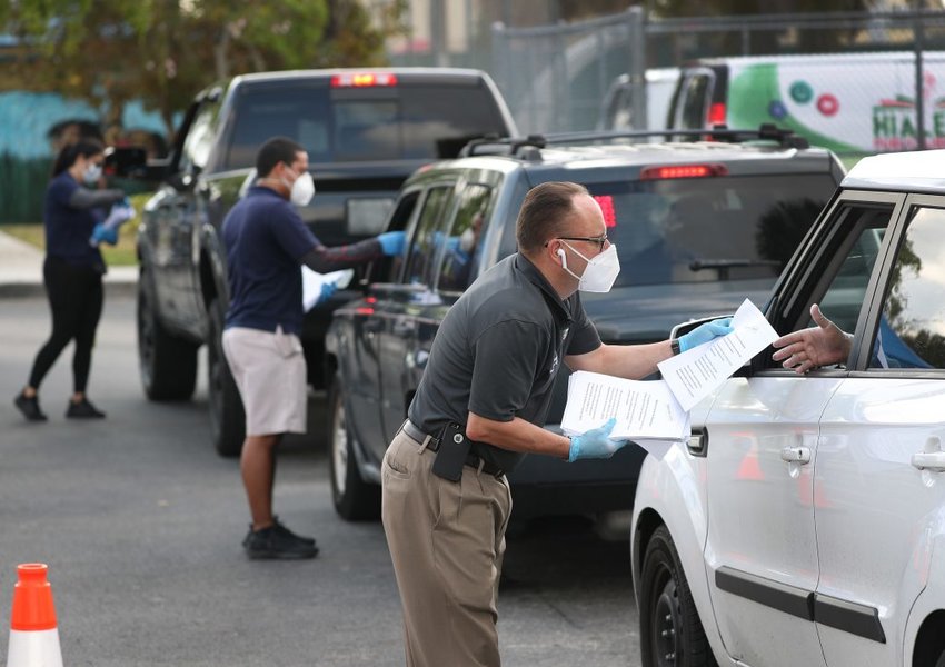City of Hialeah employees hand out unemployment applications last year to people in their vehicles in front of the John F. Kennedy Library. The city distributed the printed unemployment forms as people continued to have problems with access to the state of Florida&rsquo;s unemployment website. Credit: Joe Raedle/Getty Images