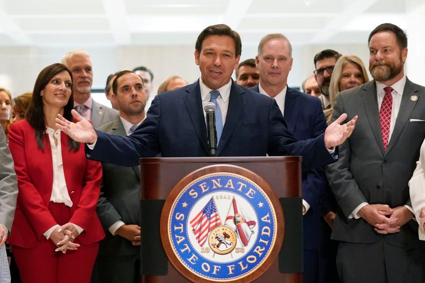 Surrounded by lawmakers, Florida Gov. Ron DeSantis speaks at the end of a legislative session, Friday, April 30, 2021, at the Capitol in Tallahassee, Fla.;  AP Photo / Wilfredo Lee