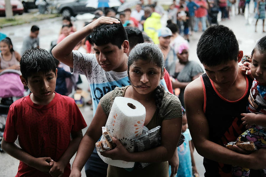 A line of residents of the rural migrant farm worker town of Immokalee, Florida, waited for emergency donations of food and supplies brought in by a volunteer group from Georgia. Hurricane Irma damaged homes, flooded their community and wiped out jobs they rely on. Credit: Spencer Platt/Getty Images
