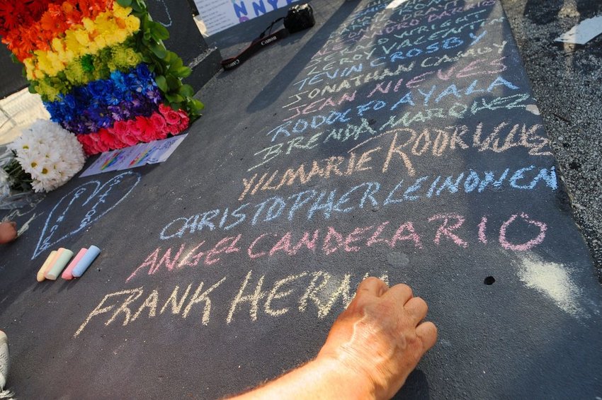 Edwin Rodriguez writes the names of the victims of the Pulse Nightclub shooting at the front of the nightclub building on June 21, 2016 in Orlando, Florida. (Photo by Gerardo Mora/Getty Images)