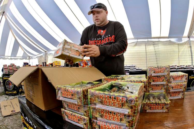 In this Jan. 2, 2015 photo, Joshua Thevenin, 29, packs boxes of unsold fireworks from inside a roadside tent; AP Photo/Chris O'Meara