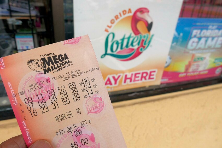 A customer shows off a Mega Millions lottery ticket.