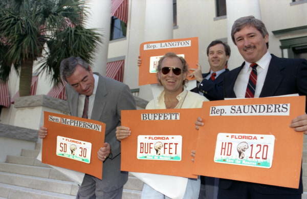 Jimmy Buffett with legislators holding Save the Manatee license plates.