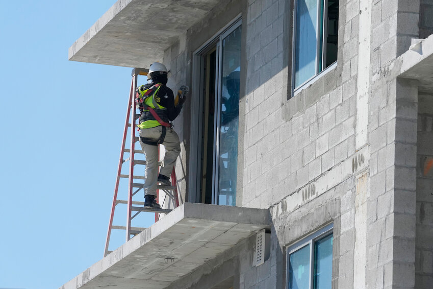 A construction worker sands a door opening at a new apartment complex, on Tuesday, February 28, 2023, in Miami.