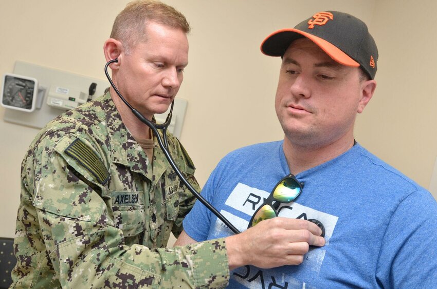 Cmdr. Frank Axelsen, a family medicine physician at Naval Hospital Jacksonville, checks a patient&rsquo;s heart during a Feb. 14, 2019 checkup.