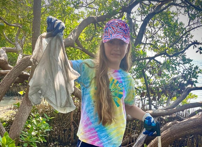 A Pinellas County student holds up a plastic bag she found during a recent coastal cleanup.