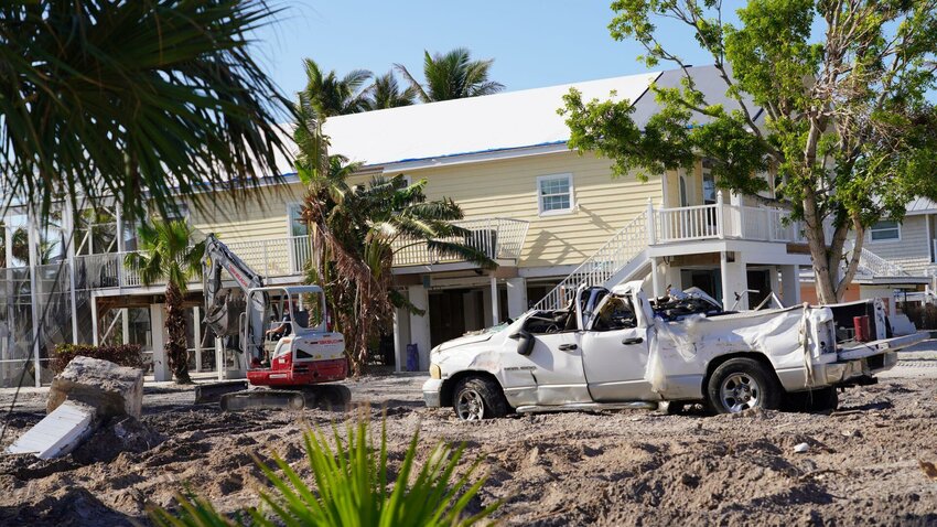 Vehicle and home damage in areas impacted by Hurricane Ian in Bonita Springs.