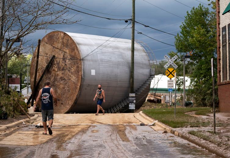 An overturned industrial storage tank in Asheville, N.C., shows the power of fast-moving flood water.