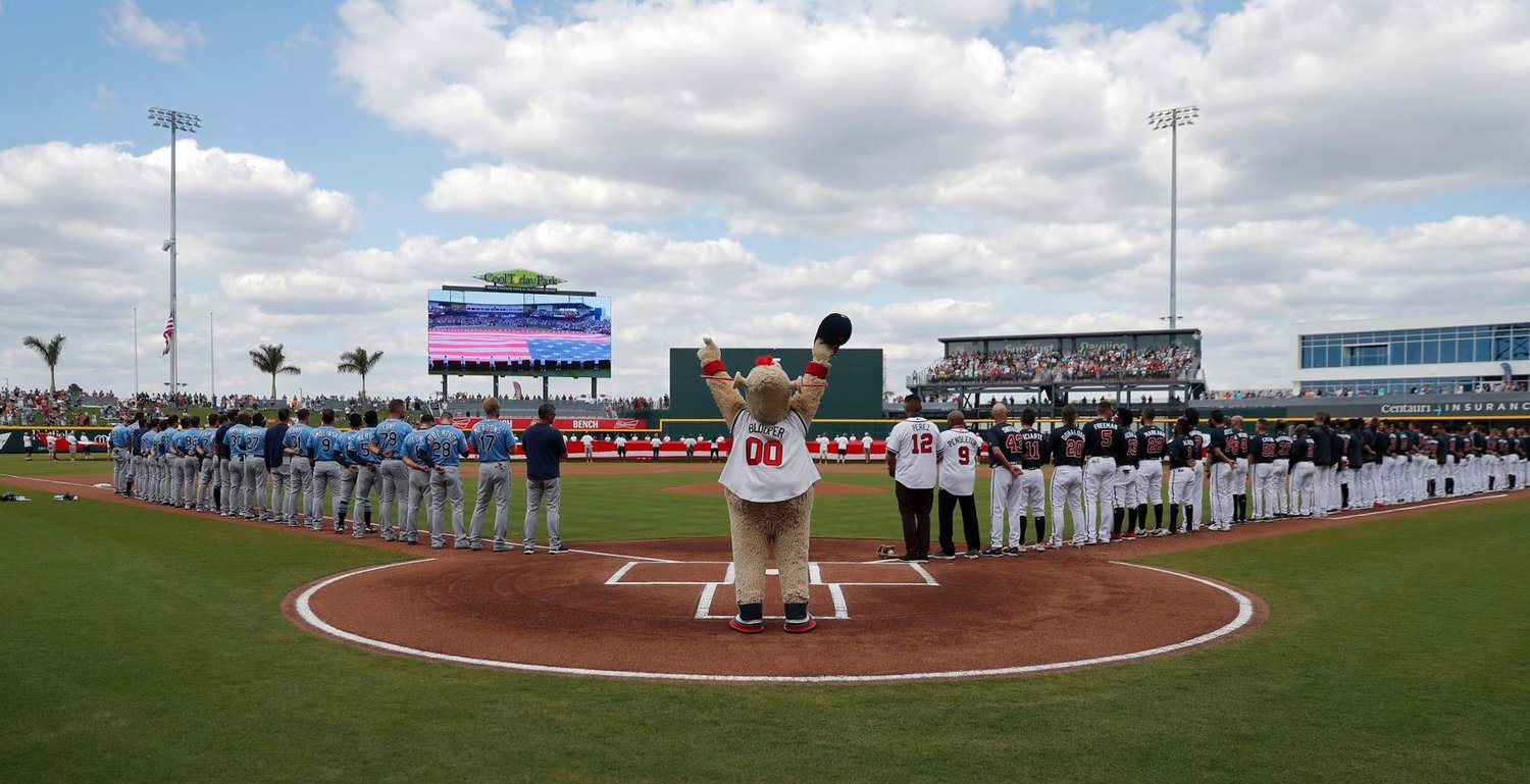 The Tampa Bay Rays and Atlanta Braves line the baselines after the national anthem and a ceremony March 24, 2019, to open the Braves' new spring training home in North Port.

John Bazemore / AP