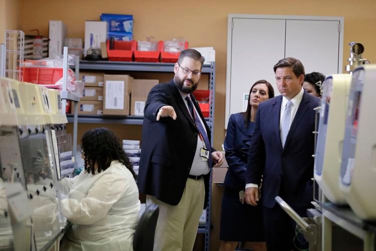 Florida Gov. Ron DeSantis (right) takes a tour of Florida's Bureau of Public Health Laboratories on Monday, March 2, 2020, with the director, Stephen White. The lab in Miami is one location in Florida where COVID-19 tests are being conducted. Brynn Anderson / AP
