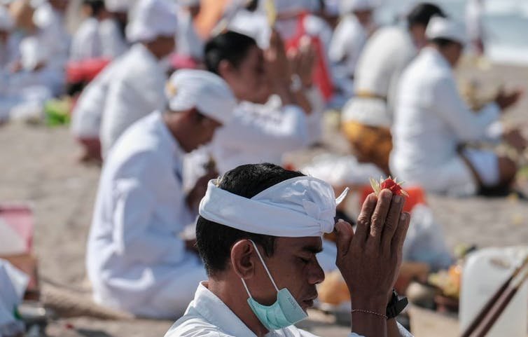 People wear a protective mask as they attend a Hindu ritual, known as Melasti, in Bali, Indonesia, on March 22. Agoes udianto/NurPhoto via Getty Images