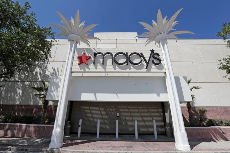 The entrance to a Macy's department store is closed behind barriers and storm shutters on Monday, March 30, 2020, in Orlando, Fla. | John Raoux / AP