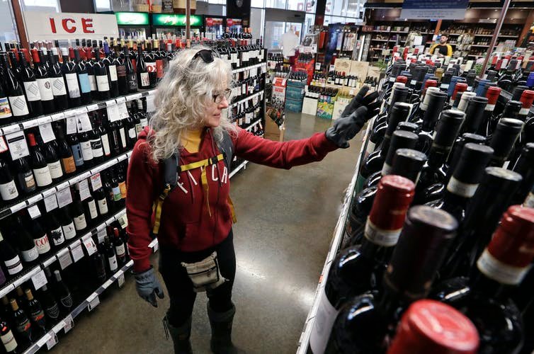 Shopping for wine in Seattle, where many liquor stores are considered “essential businesses.” AP Photo/Elaine Thompson