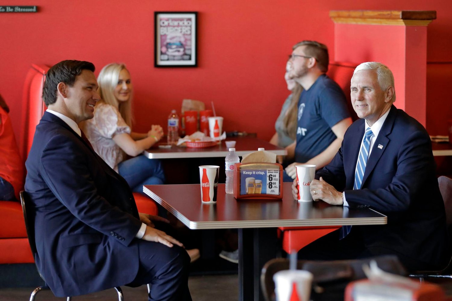 Vice President Mike Pence (right) talks to Florida Gov. Ron DeSantis as they wait for their lunch at Beth's Burger Bar on Wednesday, May 20, 2020, in Orlando, Fla. Chris O'Meara / AP