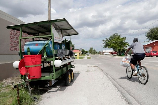 A man bicycles past a hand washing station set up outside of a popular supermarket Monday, June 8, 2020, in Immokalee, Fla., a farmworking town in rural Florida in the throes of a COVID-19 outbreak.
Lynne Sladky