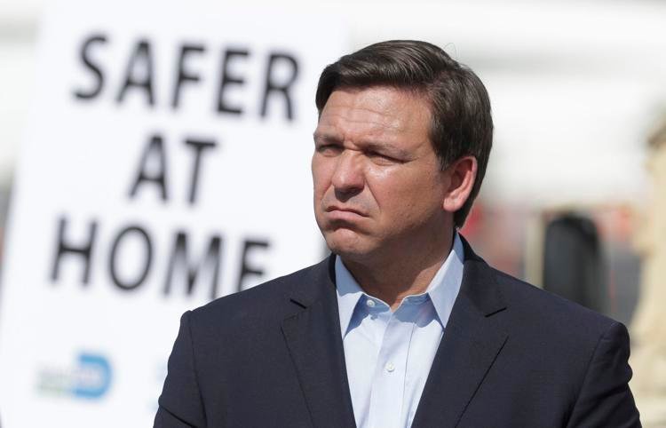 Florida Gov. Ron DeSantis listens during a news conference Monday at a drive-thru coronavirus testing site in front of Hard Rock Stadium in Miami Gardens, Fla. Wilfredo Lee / AP