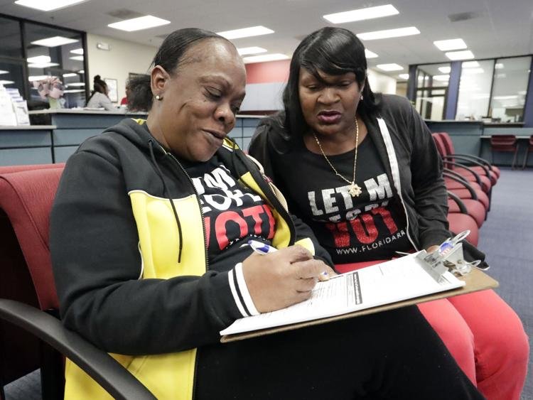 Yolanda Wilcox, left, a former felon, fills out a voter registration form as her best friend Gale Buswell looks on at the Supervisor of Elections office Tuesday, Jan. 8, 2019, in Orlando, Fla. John Raoux / AP file photo