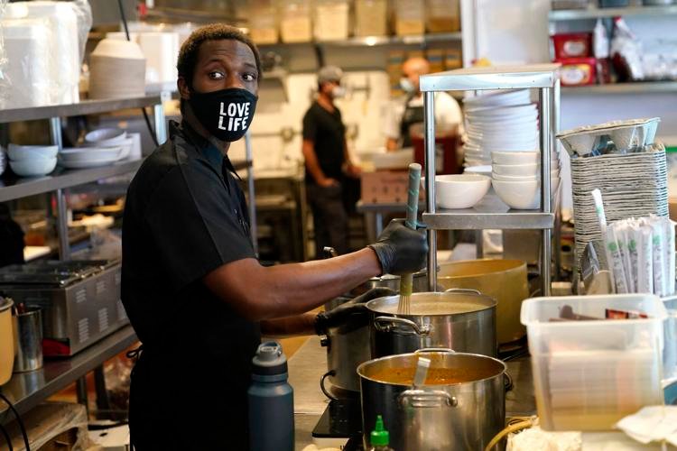 Kinoy Miller prepares food at the Love Life Cafe on Thursday, Oct. 29, 2020, in the Wynwood neighborhood of Miami. Lynne Sladky / AP