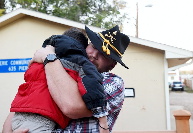 U.S. Army veteran Derek Martin gives his son a big hug at a veteran support group cookout on Nov. 7, 2015. Jon Hatch/Digital First Media/Boulder Daily Camera via Getty Images