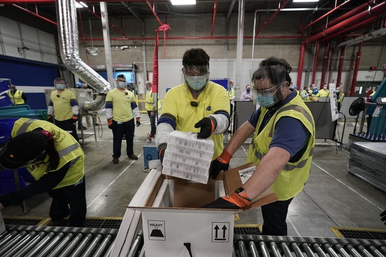 Workers prepare to ship the Pfizer COVID-19 vaccine from the company’s manufacturing plant in Kalamazoo, Michigan. Morry Gash/Pool/AFP via Getty Images