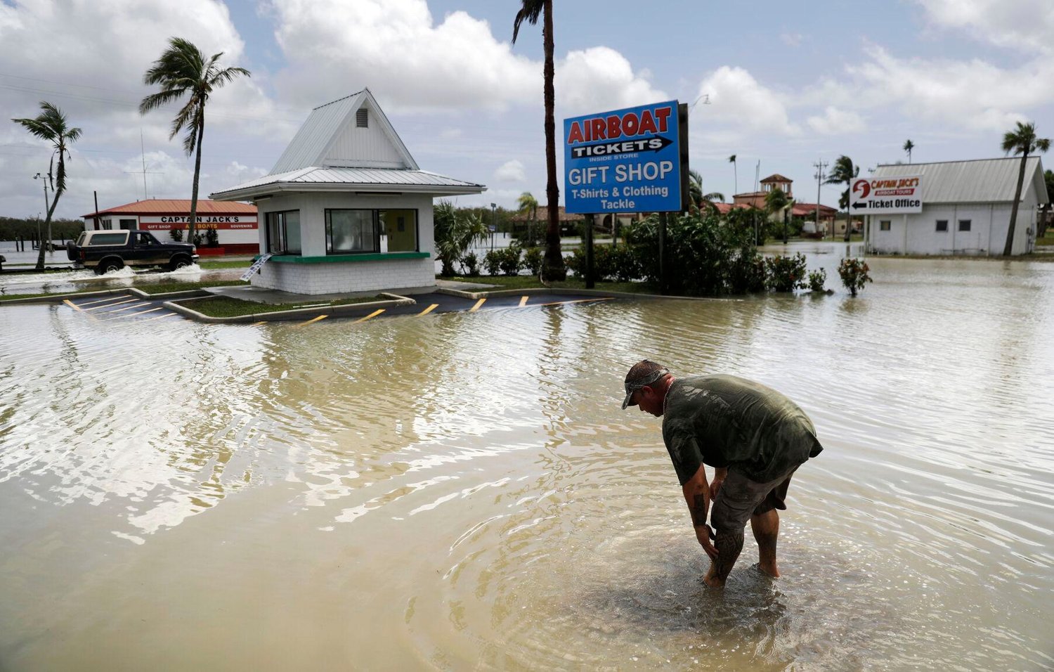 In this Sept. 11, 2017, file photo, Chris Stokes washes mud off his hands in the flooded parking lot of his father's convenience store as he cleans up the damage from Hurricane Irma in Everglades City, Fla. Coverage for hurricanes, essentially, insurance for losses from wind and rain, can be difficult to get and/or expensive if a business is located in a coastal area where storms are common. In Florida, for example, some insurers won’t sell policies. And flooding that frequently accompanies a hurricane is not included in a standard business policy. 
AP Photo/David Goldman, File