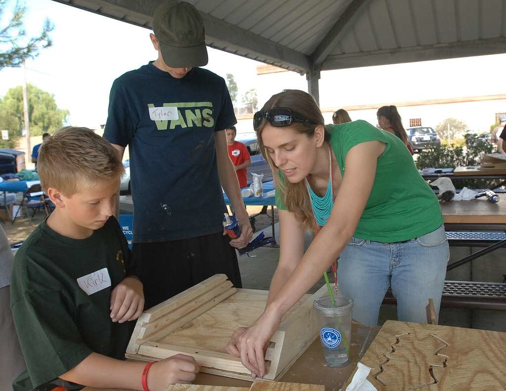 Navy conservation specialist Vanessa Shoblock works with Jackson Kuran and Tyler Russell to build a bat box.