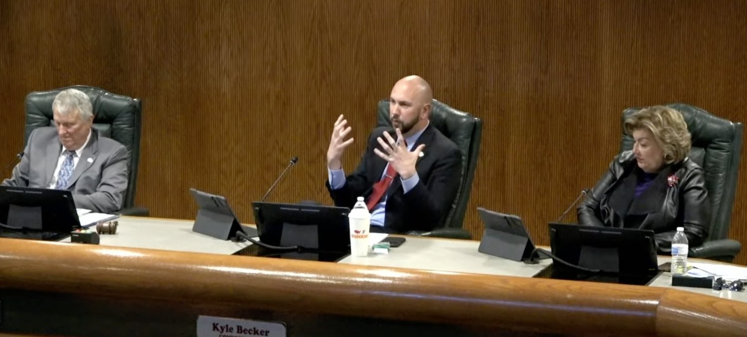 Commissioner Kyle Becker (center) speaks during the City Council meeting.