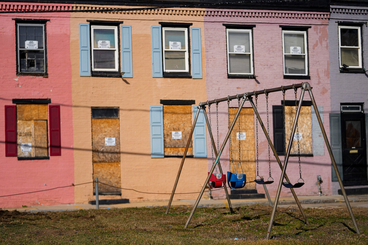 Boarded doors and windows are seen on homes adjacent to a playground, Wednesday, Feb. 15, 2023, in Baltimore. I