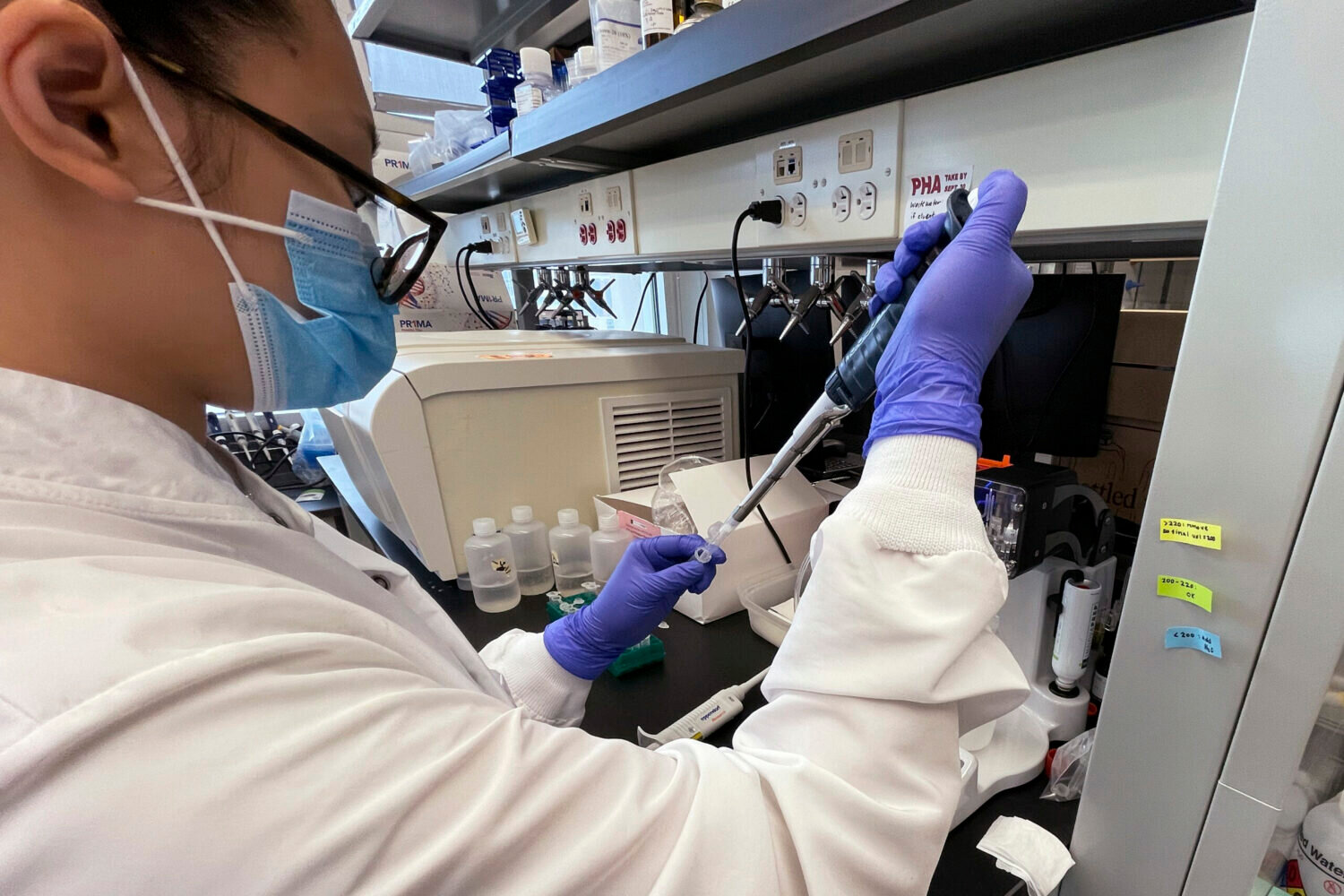 Emily Lu, a student in the environment science graduate program at Ohio State, tries to extract ribonucleic acid (RNA) from wastewater samples to test for fragments of the coronavirus, March 23, 2022 at a school lab in Columbus, Ohio.