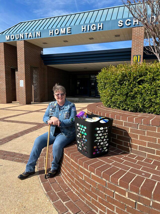 The Rev. Jami Scott of the Military Service Sisters group is pictured at Mountain Home High School with a basket of items to meet female students' needs. The program, known as Dignity for Little Sisters, helps provide access to the items. The group plans to install recycled newspaper boxes on the grounds to provide year-round access to the items, even if school is not in session.


Submitted Photo