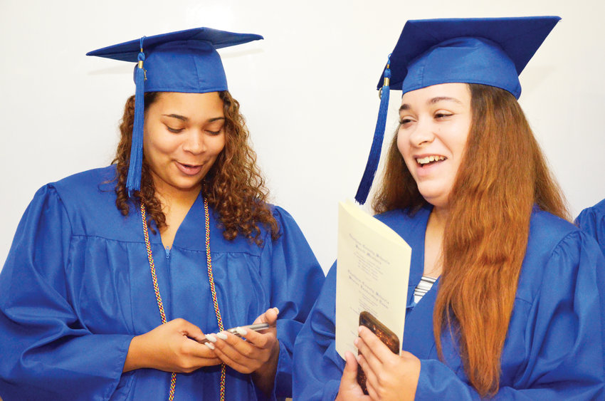 Vanessa Pritchard and Briana Person share a laugh before going in the Jordan-Matthews gym for their graduation ceremony Saturday morning in Siler City. Both girls plan to attend Central Carolina Community College in the fall.