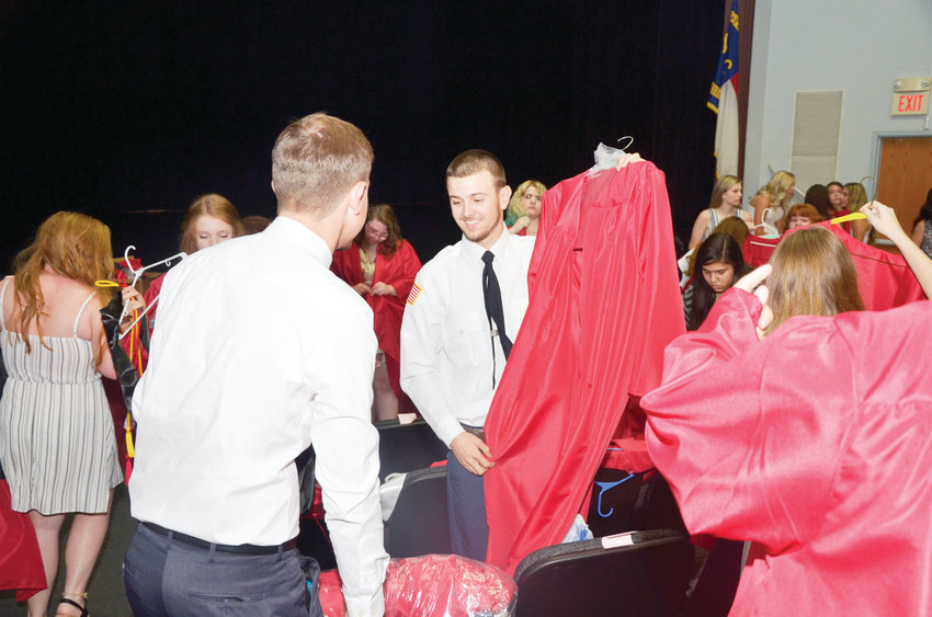 The seniors from Chatham Central High get gowns, caps and tassels ready for the ceremony at the Dennis A. Wicker Civic Center in Sanford Friday.