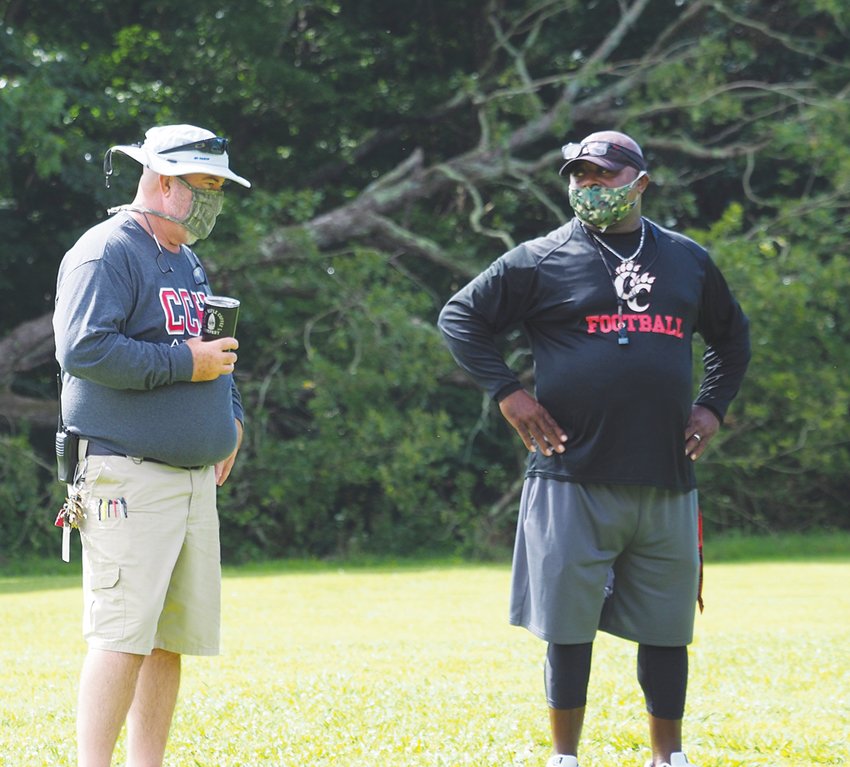 Chatham Central athletic director Bob Pegram (left) and football coach Sherman Howze watch workouts on July 8.