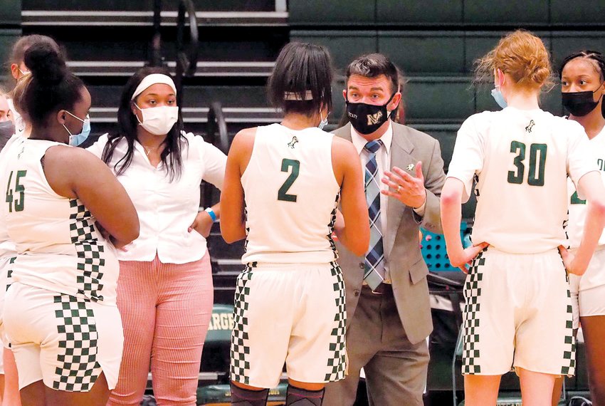 Northwood women's basketball head coach Cameron Vernon (center) speaks to his three seniors (from left to right: Jamaria Faucette, Rae McClarty, Jillian McNaught) during the Chargers' first-round playoff win over E.E. Smith on February 23.