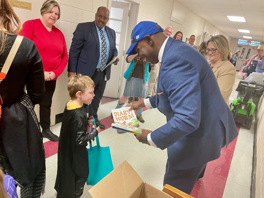 Chatham County Schools Superintendent Dr. Anthony Jackson hands out books to Pittsboro Elementary School students as part of 'Book-or-Treat' on Monday.