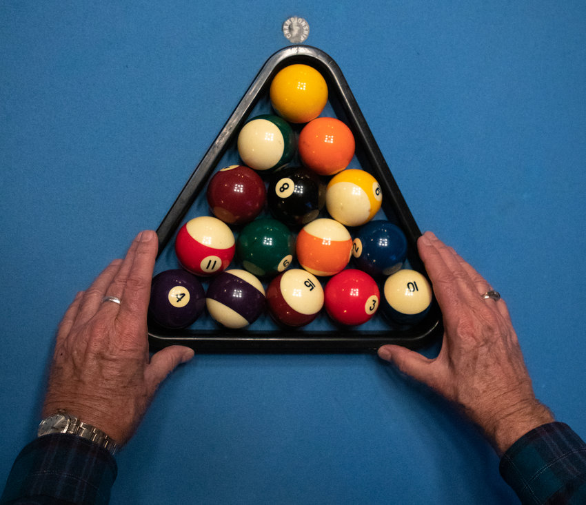 Jimmie Vaughn, member of the Pittsboro Pool League, arranges the balls in preparation for a pool match against Antonio Sloan at The Sycamore at Chatham Mills on Wednesday, Nov. 2, 2022.