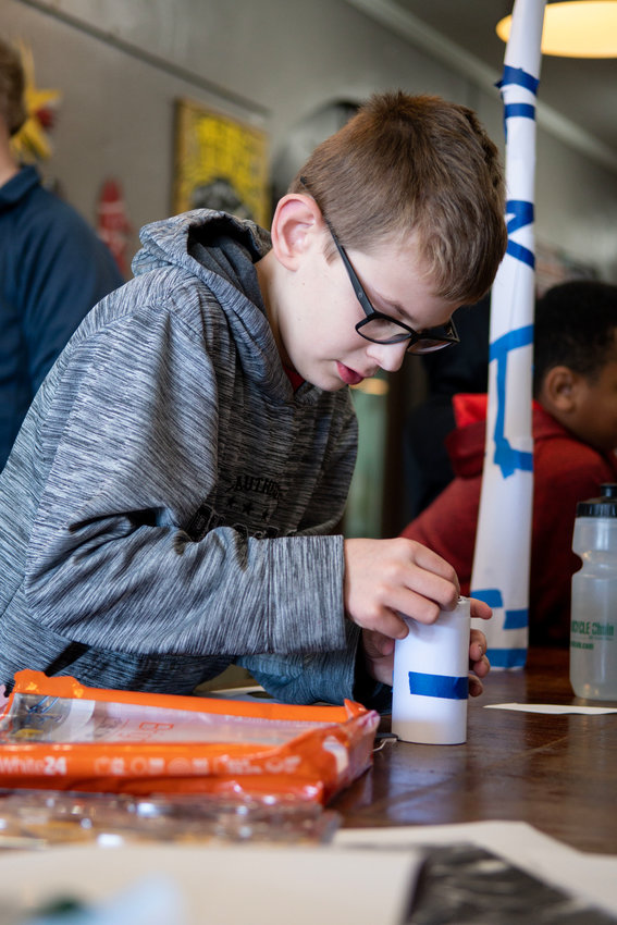 Benjamin works on the base of a tower during a STEM event for young children in Siler City.
