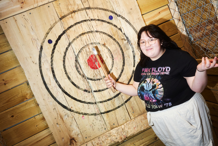 Reporter Taylor Heeden poses after hitting a bullseye at Top That Axe in Pittsboro.