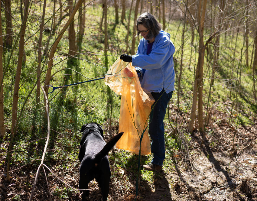 Catherine Deininger participates in Saturday's trash cleanup with her dog Arda.