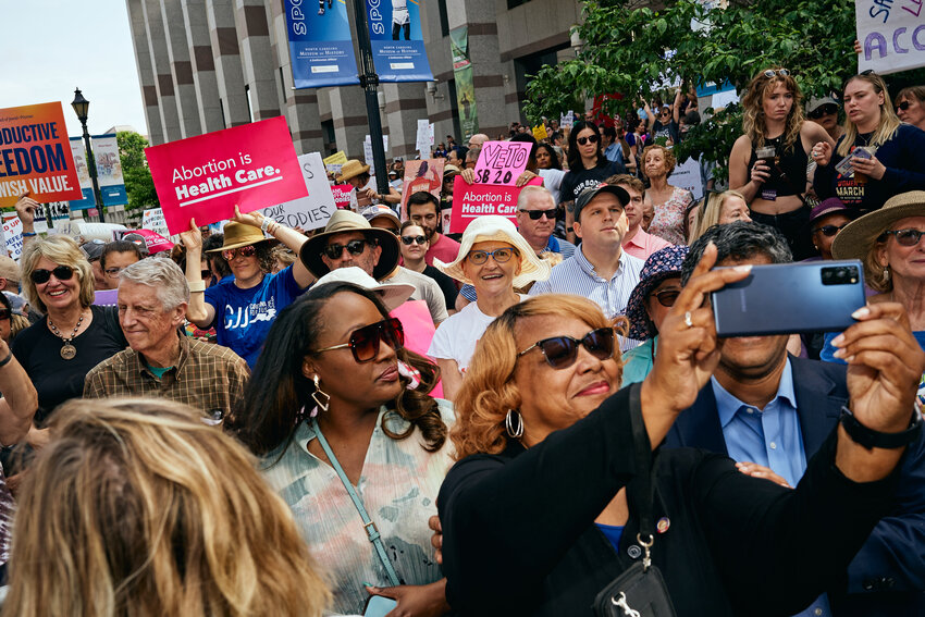 Sen. Natalie Murdock poses for a selfie with protestors in downtown Raleigh on Saturday. The rally was called to officially veto S.B. 20, a bill that Murdock said is restrictive and harmful.