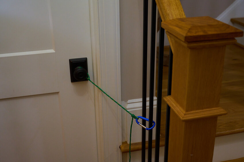 The angled floors of the Muehlbach family house means many of the latches on the doors do not properly align. To prevent the dogs from running through the door, the Muehlbachs hold it closed with rope and a carabiner.