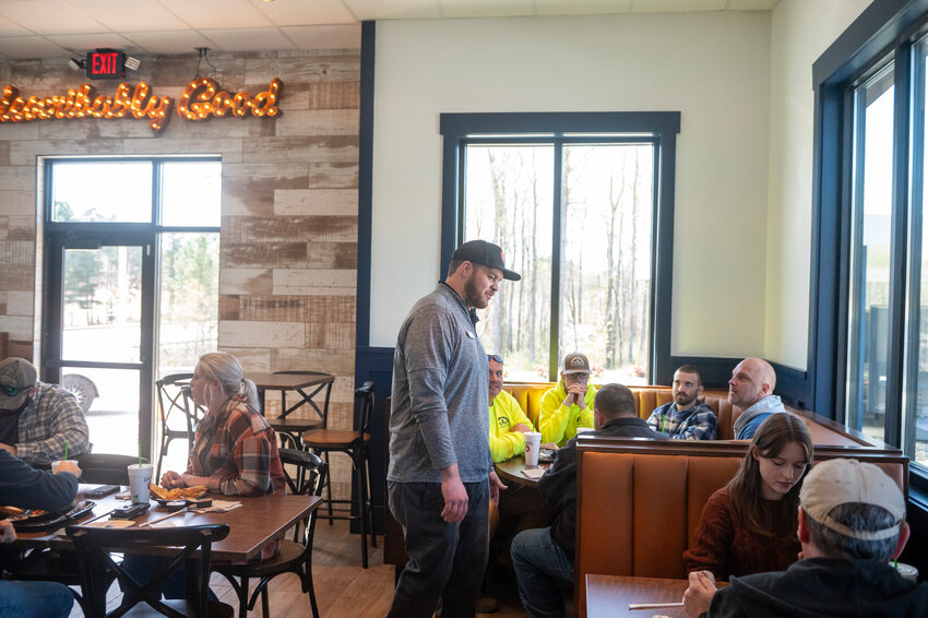 Zaxby’s Scott Holloman chats with guests during the opening of his restaurant on Monday in Pittsboro.