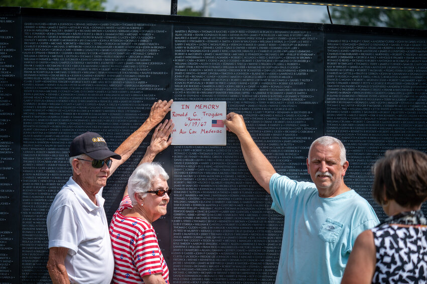 Ken Watson, Martha Trogdon Watson and Eddie Trogdon hold up a sign honoring fallen family member Ronald G. Trogdon.