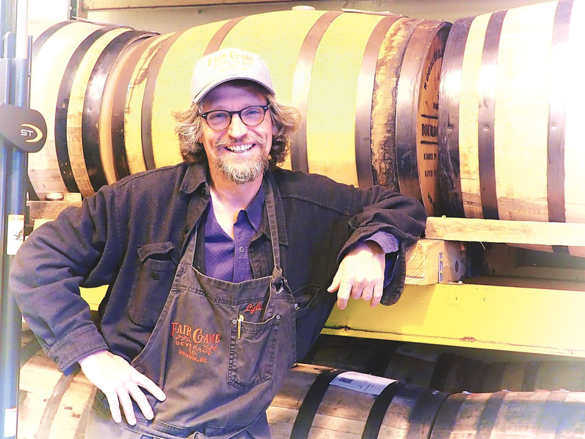 Fair Game's Lyle Estill stands with barrels where their unique spirits age.