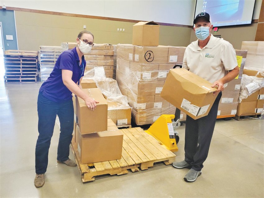 Lacee George (left) and Marty Allen work on unloading boxes of supplies at the Chatham County Agriculture &amp; Conference Center in Pittsboro, which has been partially re-purposed during the COVID-19 pandemic.