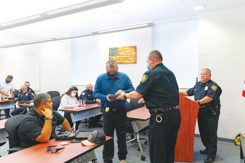 Siler City Chief of Police Chief Mike Wagner, right, watches as his officers accept their new badges last October. The department&rsquo;s officer staff stands to grow by more than 25% under the town&rsquo;s proposed budget for fiscal year 2021-22, with plans to nearly double in the next three years, according to Chief Mike Wagner.